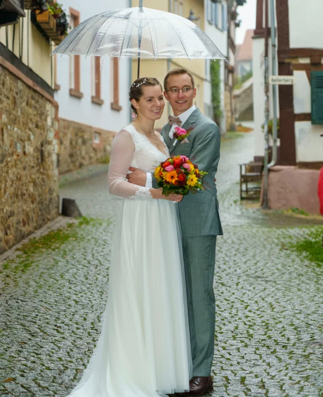 gluckliches-hochzeitspaar-unter-regenschirm